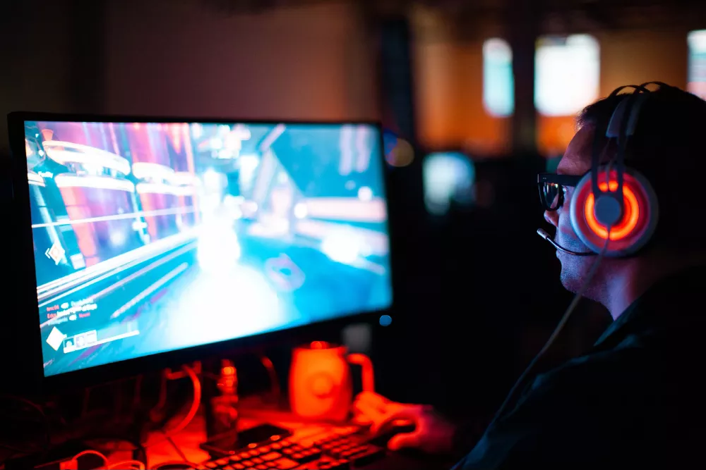Persona jugando videojuegos frente a una pantalla.